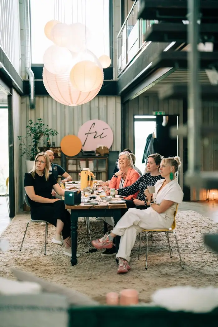 Deltagare som lyssnar vid ett långbord under ett seminarium