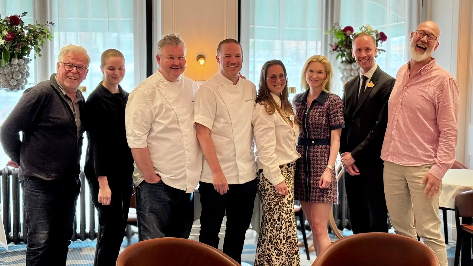 Kockar, servispersonal och gäster samlade i en restaurangmatsal