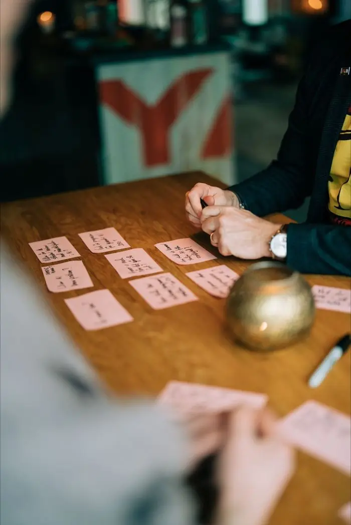 Rosa post-it-lappar med frågor på ett bord